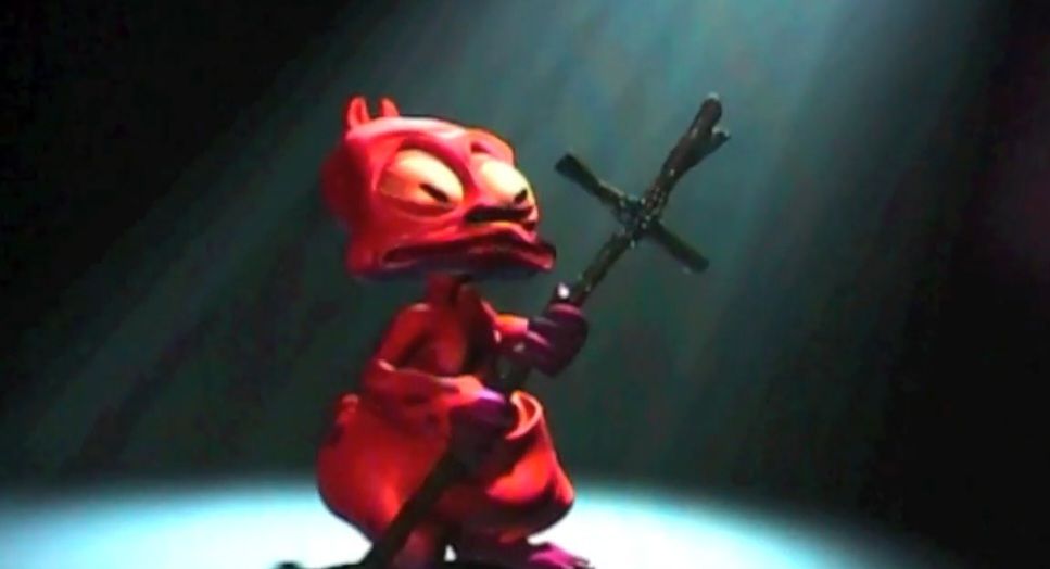 a 3d cg image of a scared little naked red alien with bug eyes and a big nose holding on to a cross in a spotlight 